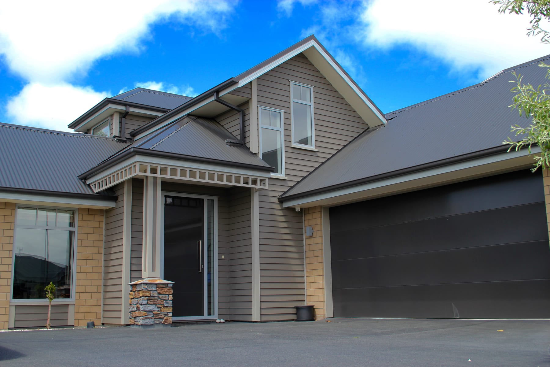 Modern grey weatherboard house with dark garage door — a 3G Griffiths Building project
